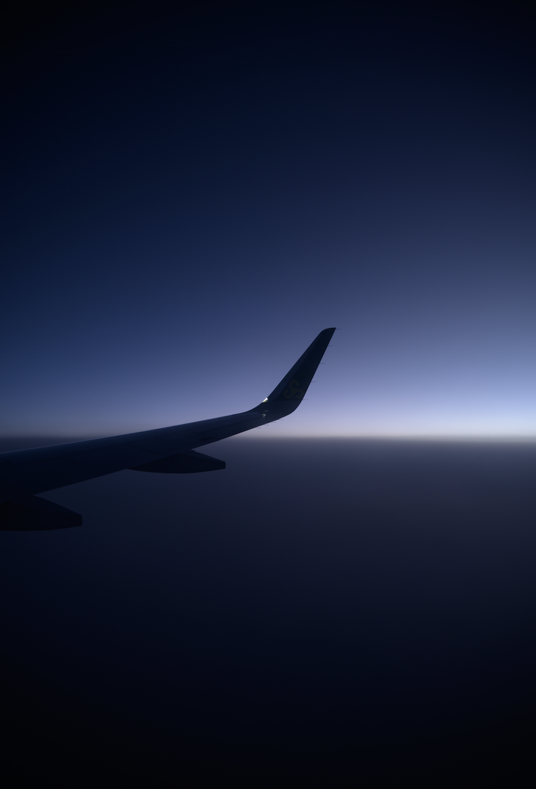 瀑布从岩石峭壁倾泻而下，周围绿植茂盛，水雾缭绕，清新自然